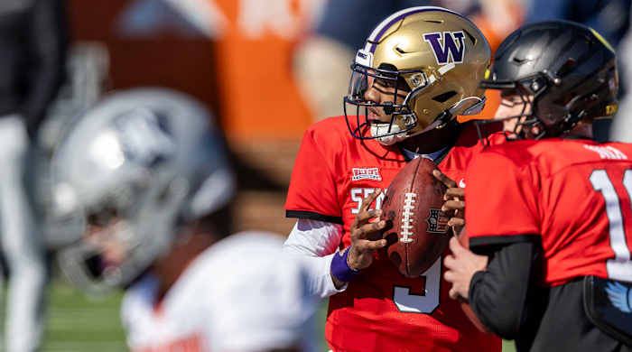 Michael Penix Jr. and Bo Nix stand next to each other each waiting to throw